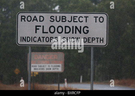 Australian flood warning road sign, during heavy rainfall. Queensland Australia Stock Photo