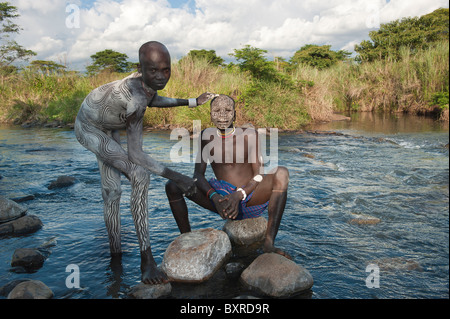 Two Surma men with body paintings in the river, Kibish, Omo River Valley, Ethiopia Africa Stock Photo