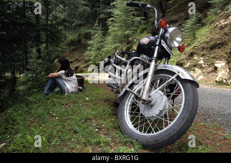 A classic Royal Enfield motorcycle and young women. Stock Photo