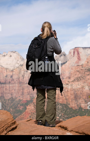 Woman photographing the view of Zion Canyon from Canyon Overlook trail, Zion National Park, Utah Stock Photo