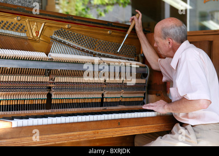 Piano tuner at work at a popular bar on Rue de Grand Pont in the old town of Sion, Switzerland Stock Photo