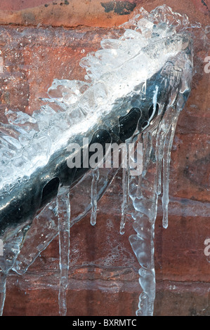 Frozen waste pipe, caused by a burst outside tap. Stock Photo