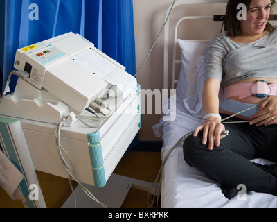 External fetal heart monitoring is performed by attaching external transducers to the mother's abdomen with elastic straps. Stock Photo