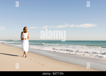 pregnant woman walking on beach Stock Photo