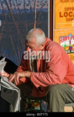Elderly senior man reading newspaper on city street in San Francisco CA USA Stock Photo