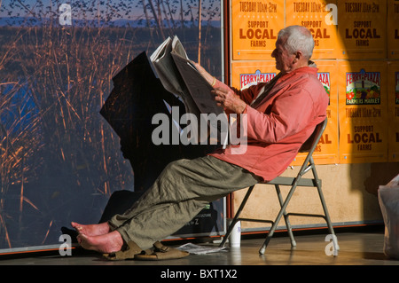 Elderly senior man reading newspaper on city street in San Francisco CA USA Stock Photo
