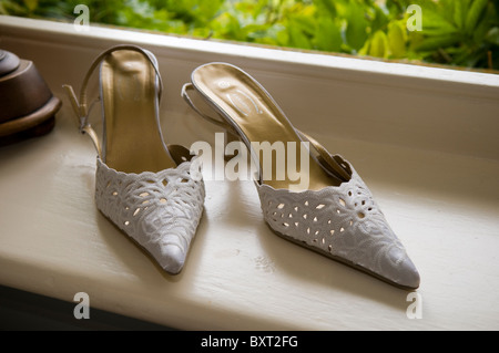 A Pair of White Bridal Shoes on a Window Sill Stock Photo
