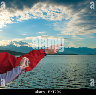 Man pointing and woman with digital camera in Inside Passage at dusk near Favorite Channel in Alaska Stock Photo