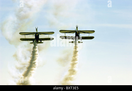 Two stunt biplanes with two wing-walking stunt performers (both girls) at an airshow. Stock Photo