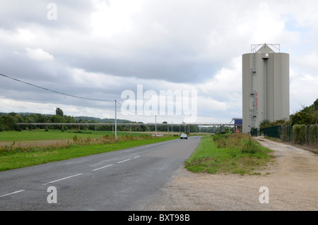 A grain silo on the D3 depatment road just west of La Ferte sous Jouarre A wcovered overhead conveyor belt links to river Marne Stock Photo