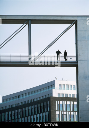 Two Men On Bridge Between Government Buildings Either Side Of River Spree Stock Photo