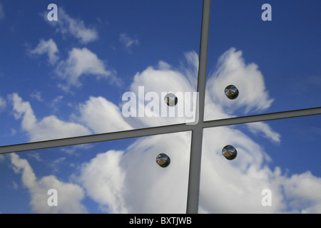 clouds reflection in a row of glass mirror panes