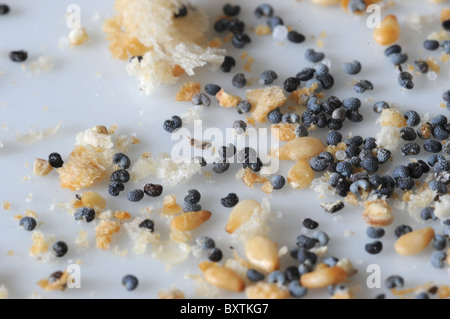 A close-up image bread crumbs, sesame seeds and poppy seeds on a white plate. Stock Photo