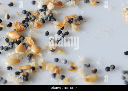 A close-up image bread crumbs, sesame seeds and poppy seeds on a white plate. Stock Photo