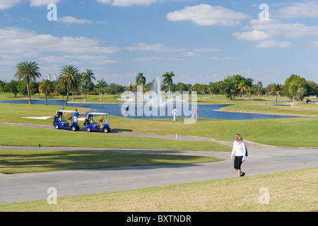 Marriott Doral Golf Resort & Spa , Miami , Florida , USA , golfers & caddies with buggies putting 18th hole of Blue Monster Stock Photo