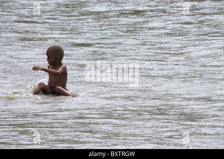 Boy on beach playing in water Stock Photo