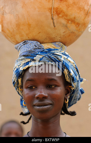 Portrait of Peul woman carrying a calabash on her head. Djenné, Mali Stock Photo