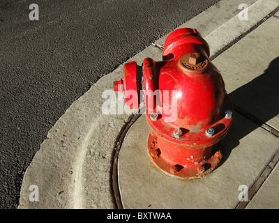 Old style round red fire hydrant on the corner of a street in the city. Stock Photo