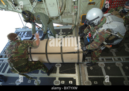 A member from the Pathfinder Platoon gets ready to jump from a C-130 transport plane with a container. Stock Photo