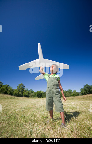A little black boy playing with a scale model of a plane (Allier - France). Petit garçon jouant avec un modèle réduit d'avion. Stock Photo