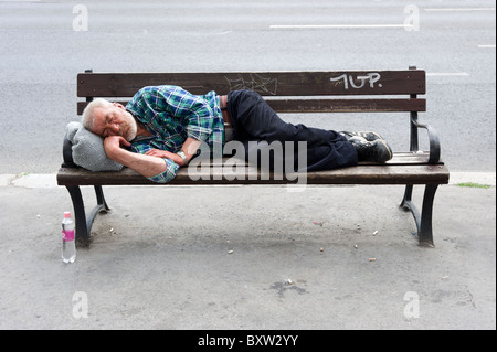 homeless man sleeping on bench Stock Photo - Alamy