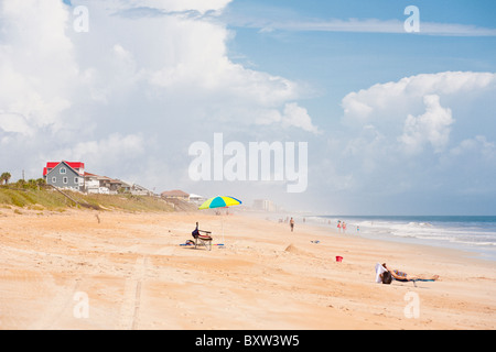 Sunbathers and sun worshipers walk along the beach at Beverly Beach, Florida Stock Photo