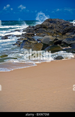 Coastal image of Coolum Beach Queensland Australia, waves breaking on rocks at sea shore, rough sell surf in background Stock Photo