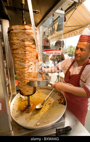 kebab kebabs turkish turkey doner meat restaurant food fast food revolving turn turning cook cooking cooked chicken slice slicin Stock Photo