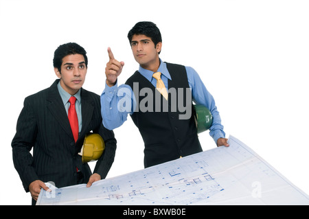 two Asian professionals working on a blueprint Stock Photo