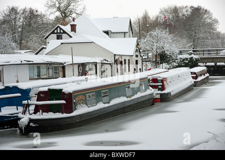 Canal boats in the snow at Farncombe Boathouse on the River Wey in Godalming Surrey Stock Photo