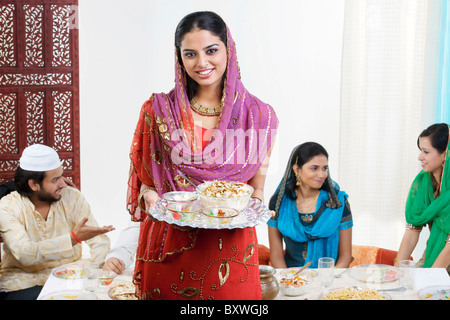 Muslim woman holding a tray with food Stock Photo