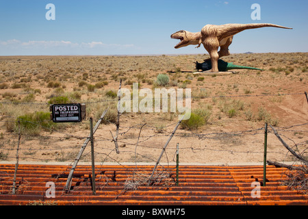 USA, Arizona, Holbrook, Dinosaur sculptures in desert along Route 66 with No Trespassing sign and road cattle guard Stock Photo