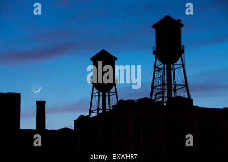 USA, New Jersey, Jersey City, Rooftop water towers and setting crescent moon Stock Photo