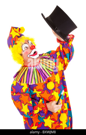 Confused clown looking for the rabbit he lost in a magic top hat. Isolated on white. Stock Photo