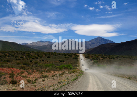 Cars kick up dust on a dirt road in the countryside. South Africa. Stock Photo