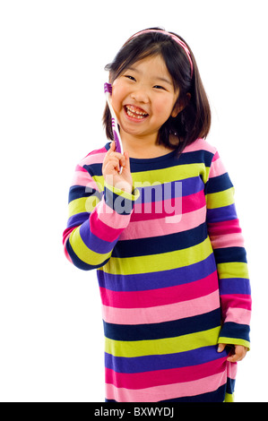 Cute little Asian girl brushing her teeth isolated over white Stock Photo