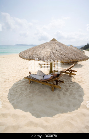 Young woman relaxing on the beach Stock Photo
