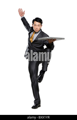 Businessman in fighting stance holding laptop Stock Photo