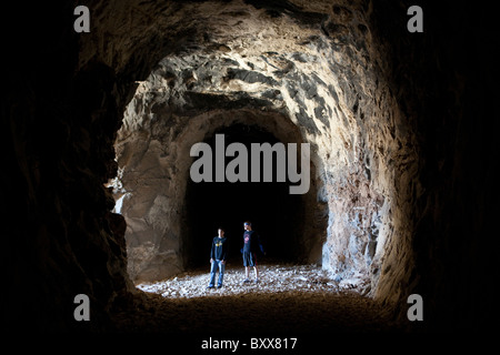 Hikers inside abandoned railroad tunnel in West Texas look across Rio Grande River into Mexican state of Coahuila Stock Photo