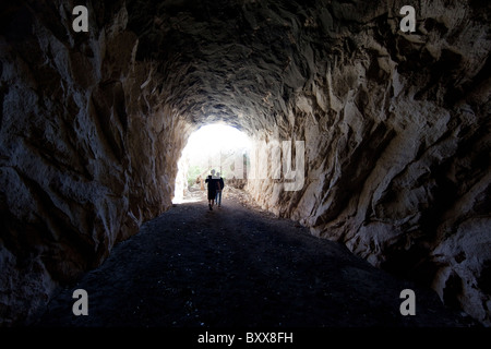 Hikers walk through abandoned railroad tunnel along Rio Grande River in Lake Amistad National Recreation Area in southwest Texas Stock Photo