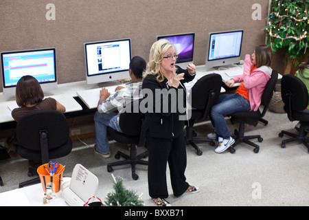 Teacher monitors high school students in computer lab at charter school ...