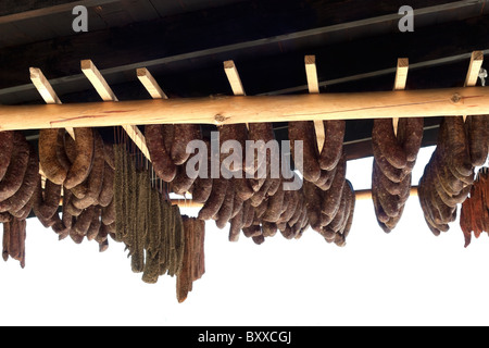 Bulgarian,home made sausages and fillet hanging on wooden sticks.Drying process Stock Photo