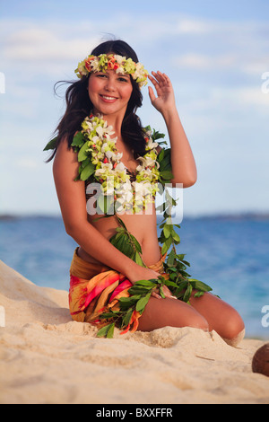 hula dancer sitting on the beach Stock Photo