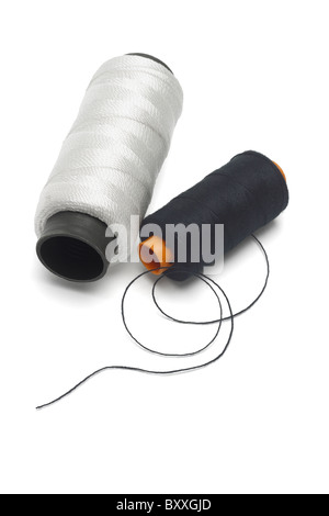 Bobbins of black and white cotton threads on isolated background Stock Photo