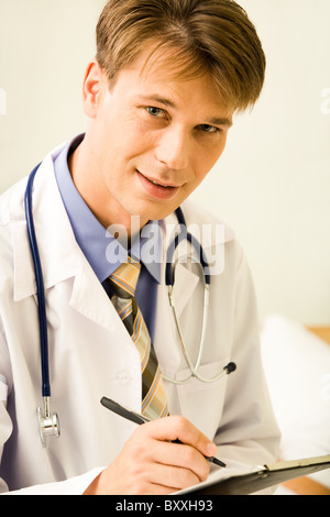 Portrait of confident male doctor ready to write something while looking at camera Stock Photo