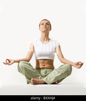 Image of young pretty woman sitting in pose of lotus and looking upwards Stock Photo