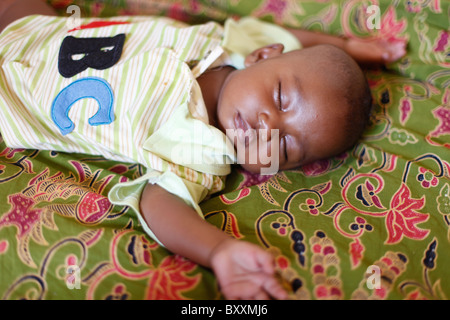 A Fulani child sleeps on a mat in Burkina Faso's capital city of Ouagadougou. Stock Photo
