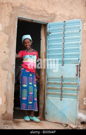 A young Fulani woman pauses in the doorframe in the town of Djibo in northern Burkina Faso. Stock Photo