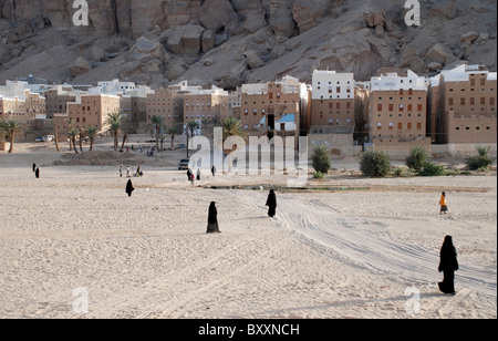 Women covered in black outside the city of Shibam , Yemen . Arabia . Stock Photo