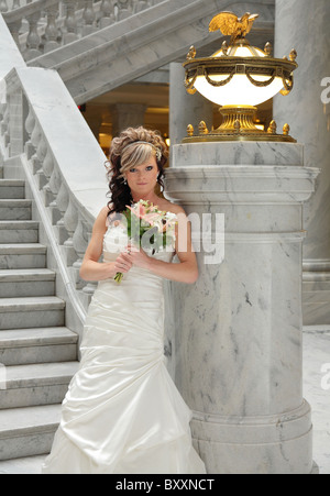 beautiful modern bride standing near marble staircase Stock Photo
